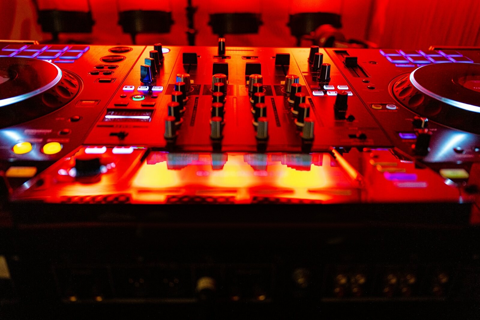 Mesa de mistura de DJ sob luz vermelha