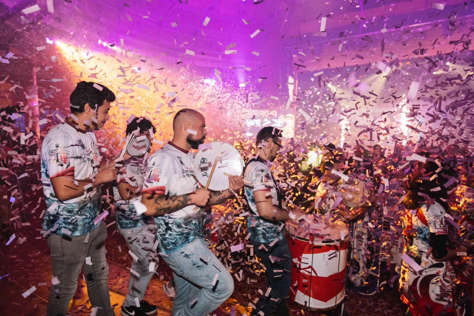 Grupo de percussão em atuação sob uma chuva de confettis