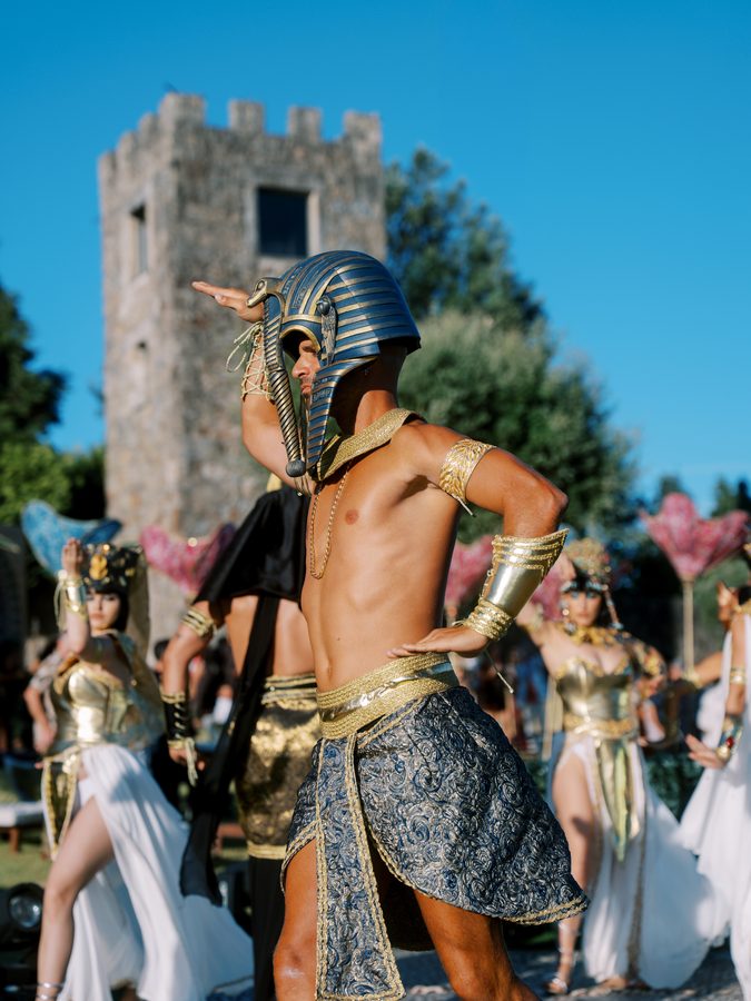 Bailarino com máscara de faraó, entre bailarinas egípcias, num jardim ao fim da tarde no evento WILD