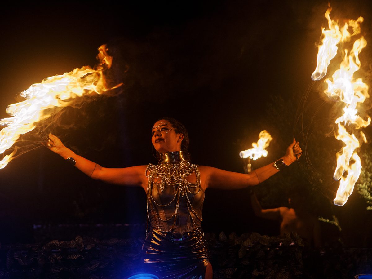 Artista de fogo a girar chamas em cada mão, no evento WILD