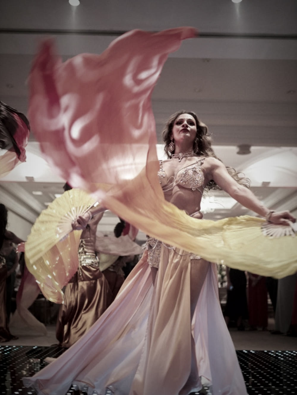 Bailarina a girar leques de véus de seda