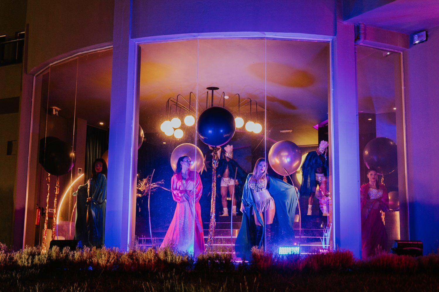 Espetáculo dentro de um pavilhão de vidro iluminado a azul